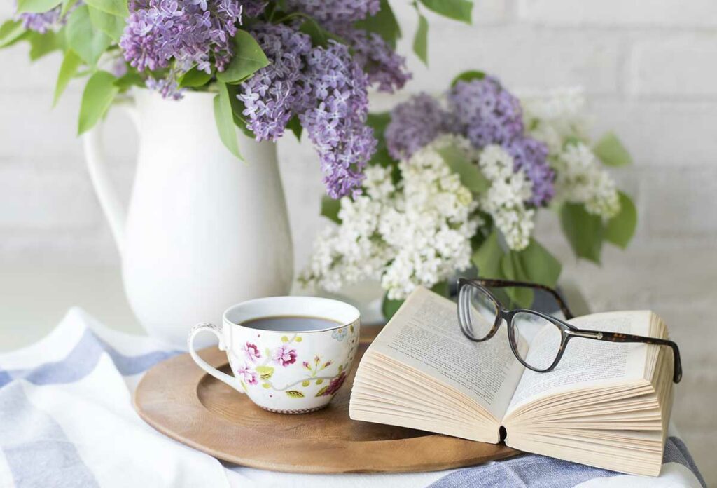 coffee, book, and flowers on a tray