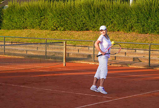 woman playing tennis on clay court