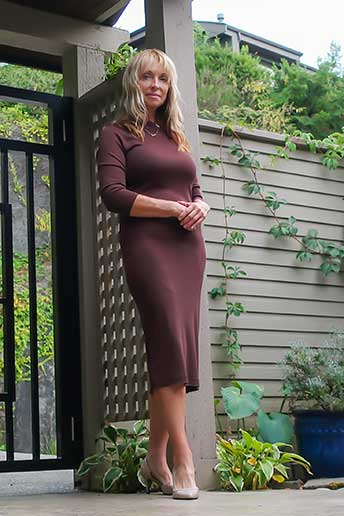 mature woman in a pretty sleek brown dress in the garden