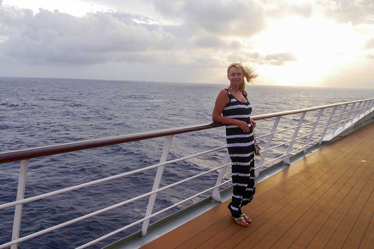 mature woman standing on the deck of a ship