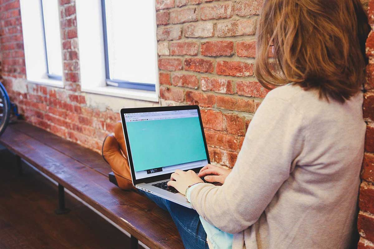mature woman working on a laptop by the window